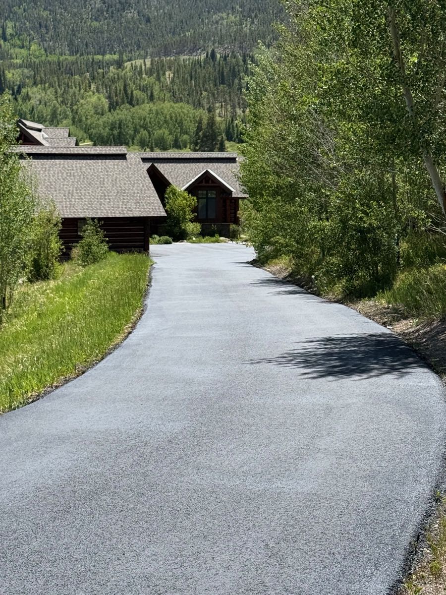 Long tree-lined driveway after seal coating — Grand County, CO